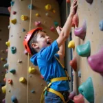 A person attempting rock climbing at an indoor climbing wall showing determination